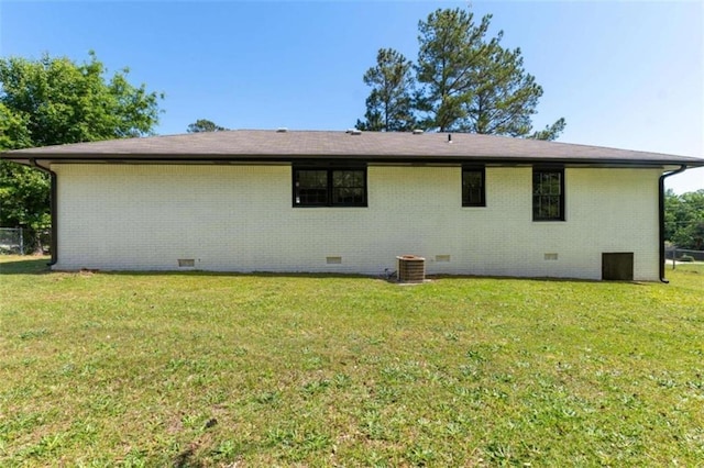 rear view of house with crawl space, a yard, brick siding, and central AC unit