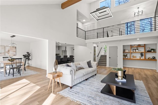 living room featuring a wealth of natural light, stairway, and wood finished floors