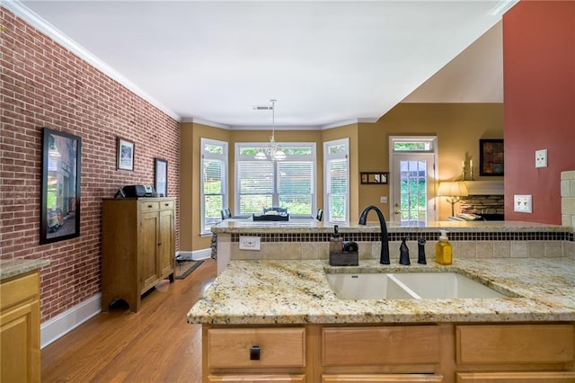 1997 Shaker Falls Ln, Lawrenceville, GA 30045 - kitchen featuring a sink, baseboards, brick wall, light wood-style floors, and light stone counters