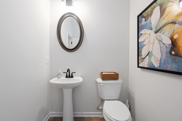 bathroom featuring toilet and baseboards