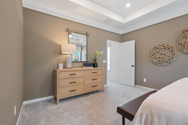 bedroom featuring a tray ceiling, light colored carpet, and baseboards