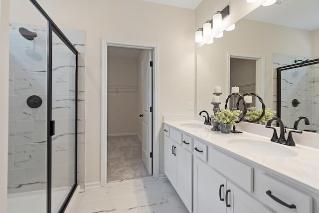 bathroom with a walk in closet, marble finish floor, a sink, and a shower stall