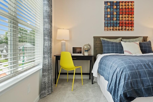 bedroom featuring multiple windows, baseboards, and carpet flooring