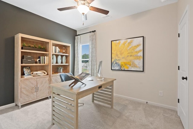 office space featuring baseboards, ceiling fan, visible vents, and light colored carpet