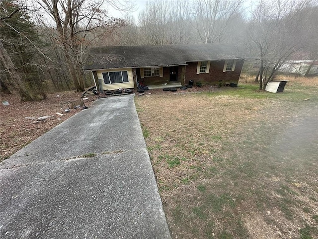 ranch-style home featuring aphalt driveway and brick siding