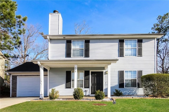 traditional home with a garage, driveway, a chimney, and a front yard