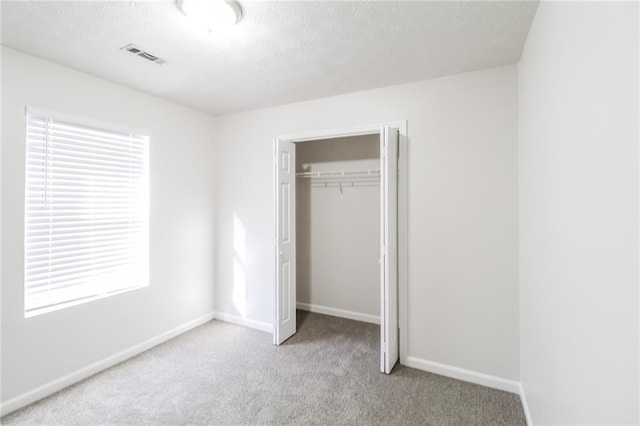 unfurnished bedroom featuring a closet, baseboards, visible vents, and carpet floors