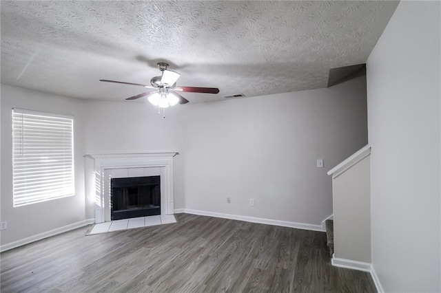 unfurnished living room featuring baseboards, wood finished floors, visible vents, and ceiling fan