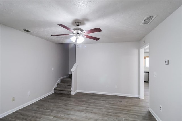 unfurnished living room featuring a textured ceiling, wood finished floors, visible vents, and ceiling fan