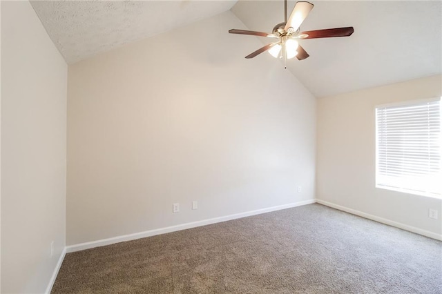 carpeted spare room with vaulted ceiling, a ceiling fan, baseboards, and a textured ceiling