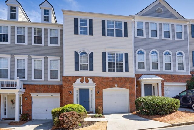 townhome / multi-family property with brick siding, concrete driveway, and a garage