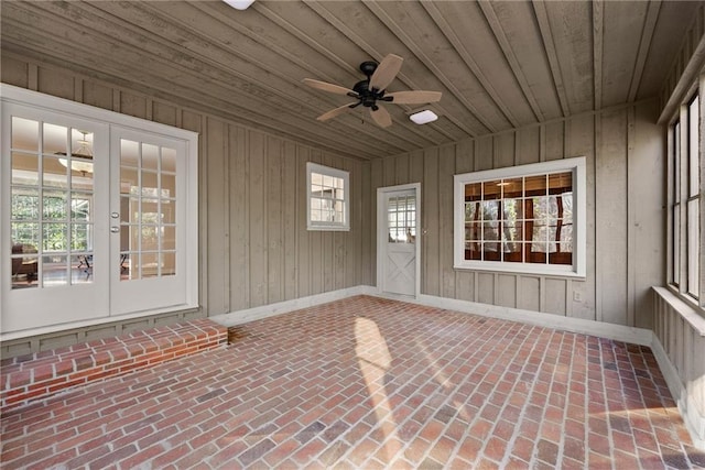 unfurnished sunroom with ceiling fan, wood ceiling, and french doors