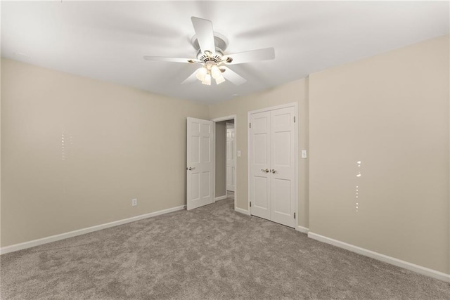 empty room featuring ceiling fan and light colored carpet