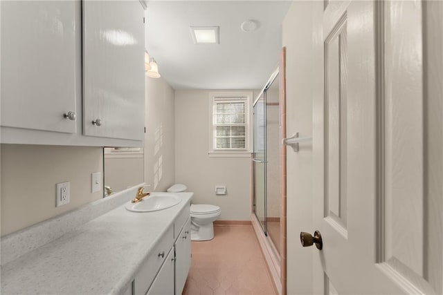 bathroom with a shower with shower door, toilet, and vanity