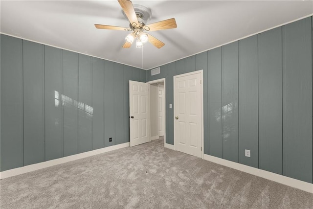 unfurnished bedroom with ceiling fan and light colored carpet