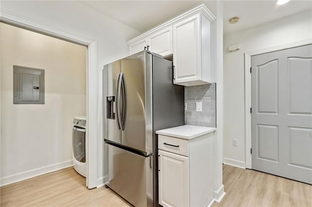 kitchen featuring stainless steel refrigerator with ice dispenser, tasteful backsplash, light hardwood / wood-style flooring, electric panel, and white cabinetry