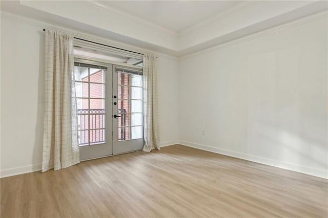 spare room with french doors, light wood-type flooring, and crown molding