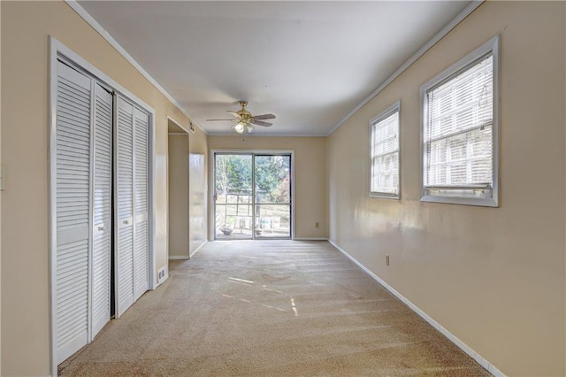 hall with crown molding and light carpet