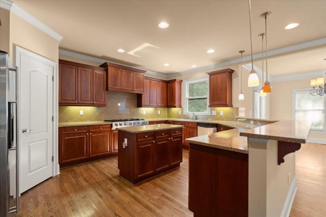 10565 Highgate Manor Ct, Duluth, GA 30097 - kitchen with wood finished floors, a peninsula, appliances with stainless steel finishes, a kitchen bar, and ornamental molding