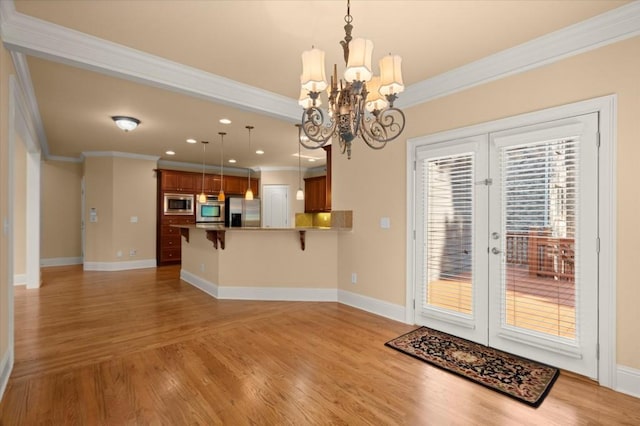 10565 Highgate Manor Ct, Duluth, GA 30097 - kitchen featuring appliances with stainless steel finishes, ornamental molding, french doors, a kitchen bar, and light wood-type flooring