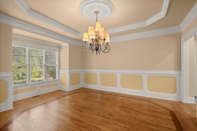 10565 Highgate Manor Ct, Duluth, GA 30097 - empty room featuring a chandelier, a raised ceiling, ornamental molding, wood finished floors, and a wainscoted wall