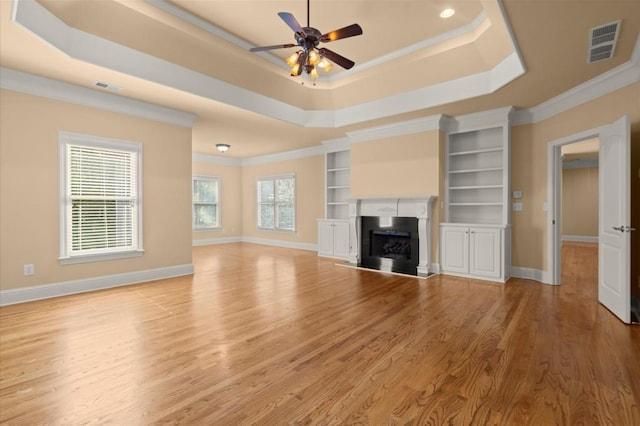 10565 Highgate Manor Ct, Duluth, GA 30097 - unfurnished living room featuring a raised ceiling, ceiling fan, ornamental molding, light wood-style flooring, and a fireplace