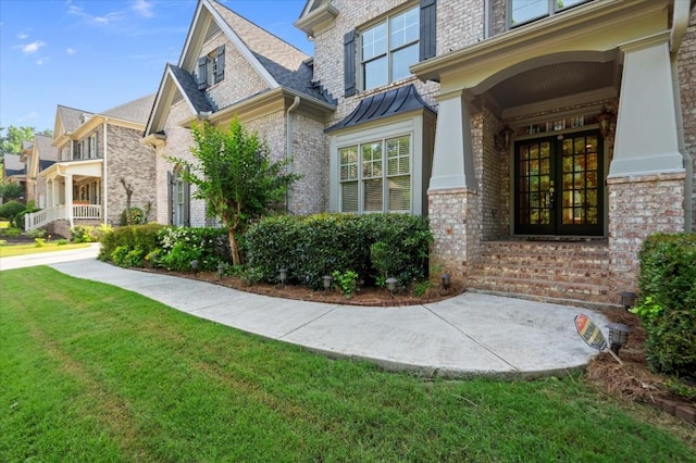 10565 Highgate Manor Ct, Duluth, GA 30097 - view of home's exterior with french doors, brick siding, a yard, and a standing seam roof