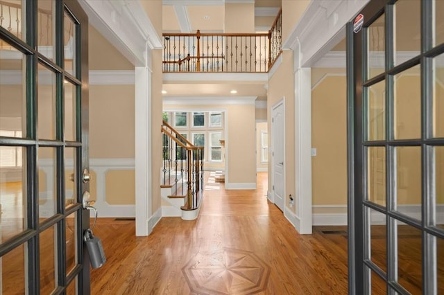 10565 Highgate Manor Ct, Duluth, GA 30097 - entrance foyer featuring stairway, light wood finished floors, ornamental molding, a towering ceiling, and french doors