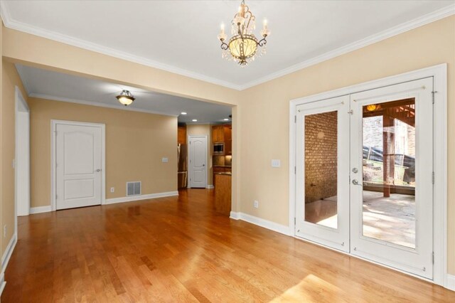10565 Highgate Manor Ct, Duluth, GA 30097 - empty room featuring a chandelier, light wood-style floors, ornamental molding, and french doors