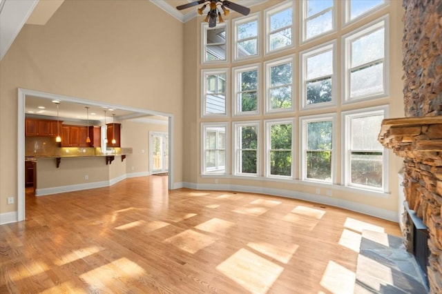 10565 Highgate Manor Ct, Duluth, GA 30097 - unfurnished living room with a high ceiling, light wood-type flooring, a ceiling fan, ornamental molding, and plenty of natural light