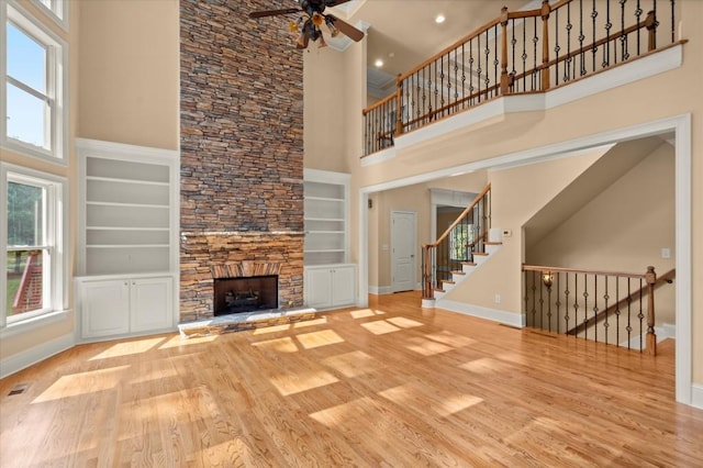 10565 Highgate Manor Ct, Duluth, GA 30097 - unfurnished living room featuring a high ceiling, ceiling fan, built in features, wood finished floors, and a fireplace