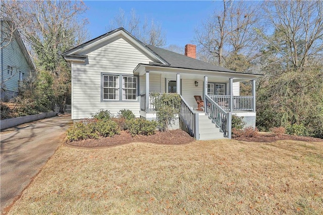 view of front of property featuring covered porch and a front yard