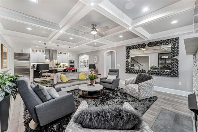 living room with beamed ceiling, light wood-type flooring, crown molding, and coffered ceiling