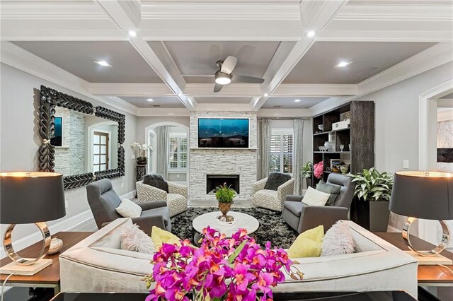 living room with hardwood / wood-style floors, plenty of natural light, a fireplace, and beamed ceiling