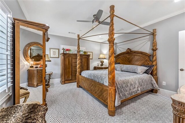 carpeted bedroom with ceiling fan, ornamental molding, and multiple windows