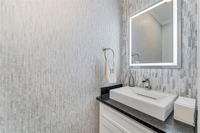 bathroom with vanity and ornamental molding