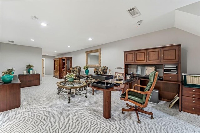 office space with light carpet and vaulted ceiling