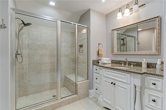 bathroom featuring tile patterned floors, vanity, and an enclosed shower