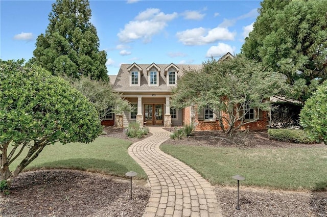 view of front of property featuring a front yard and french doors