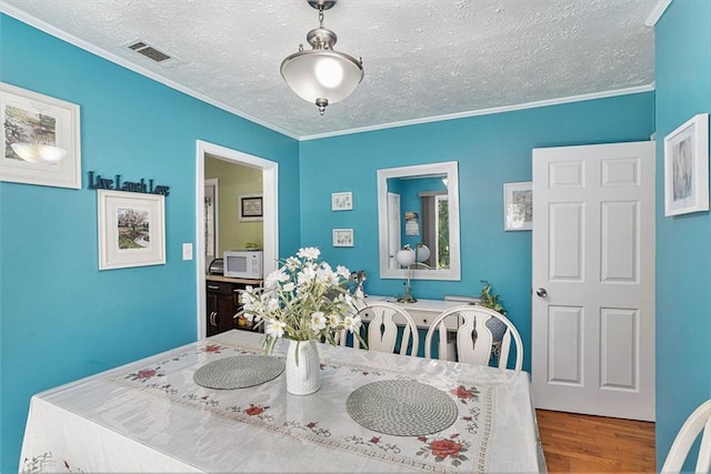 141 Parr Wade Rd SE, Cartersville, GA 30120 - dining room with wood finished floors, a textured ceiling, and crown molding