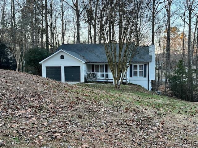 single story home featuring a porch and a garage