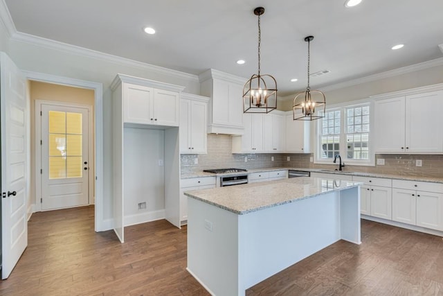 kitchen featuring white cabinets, pendant lighting, a center island, and light stone counters