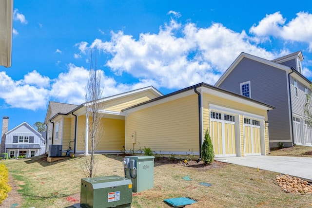 view of home's exterior featuring cooling unit, a garage, and a yard