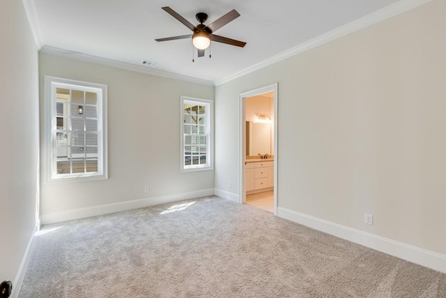 unfurnished bedroom featuring ensuite bath, ceiling fan, crown molding, and light colored carpet