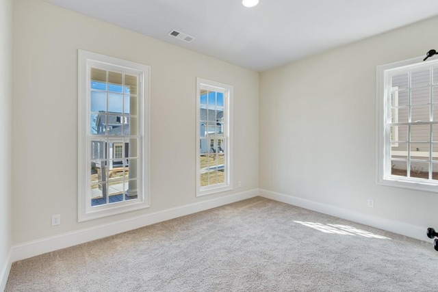 carpeted spare room featuring plenty of natural light