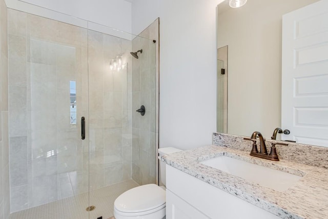 bathroom with vanity, a shower with shower door, and toilet