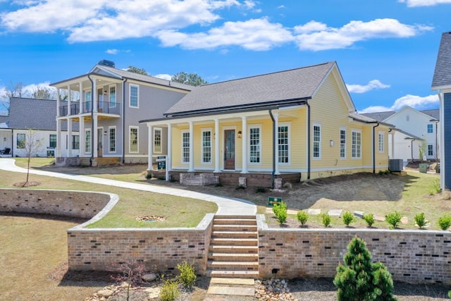 back of property featuring covered porch, central AC unit, and a lawn