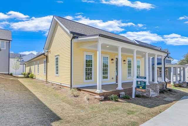 view of property exterior featuring a porch and a lawn