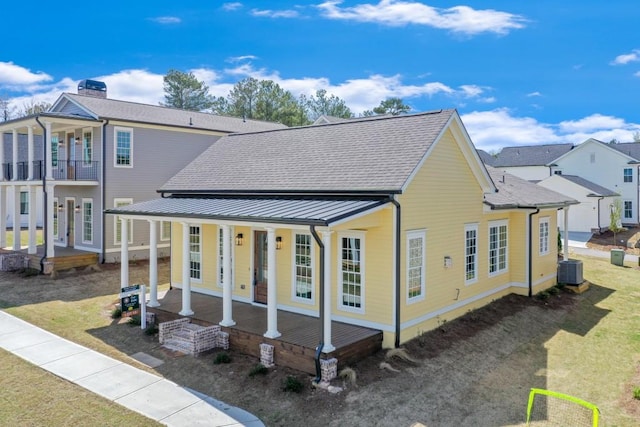 929 Hilltop Park Ct, Dacula, GA 30019 - back of property with a porch, a standing seam roof, central air condition unit, and roof with shingles