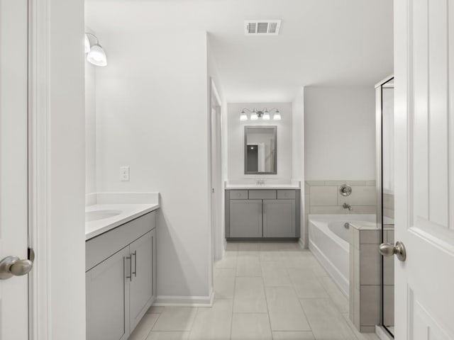 bathroom featuring tile patterned floors, vanity, and a bathing tub